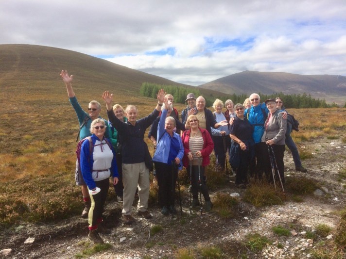 A photo of a group of walkers waving and smiling at the camera.